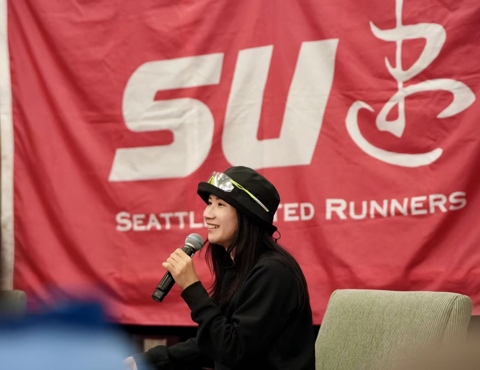 A Seattle United Runners volunteer speaking in front of the club banner