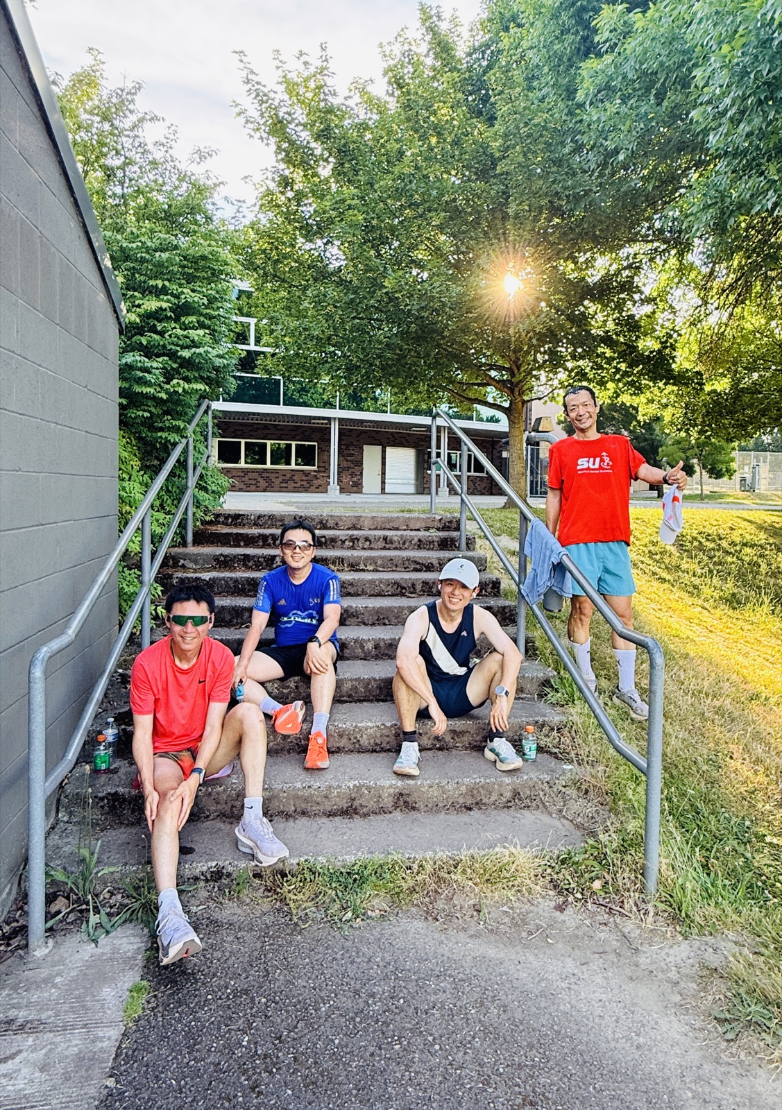 Seattle United Runners members resting together on track-side steps